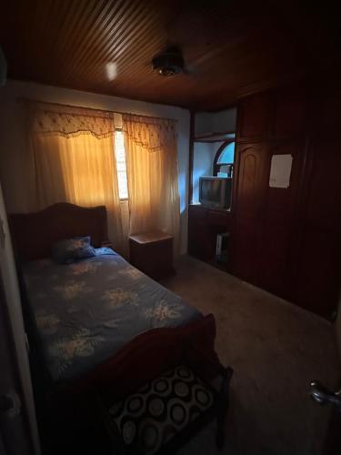 um pequeno quarto com uma cama e uma televisão em Habitación individual festival em Valledupar