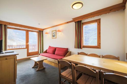 un salon avec un canapé rouge et une table dans l'établissement Résidence Les Valmonts - maeva Home - Appartement 3 Pièces 6 Personnes - Confort MAE-2689, à Saint-Martin-de-Belleville