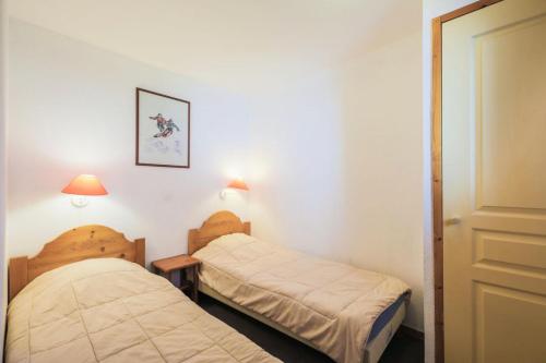 2 camas en una habitación pequeña con 2 lámparas en Résidence Les Valmonts - maeva Home - Appartement 3 Pièces 6 Personnes - Co 89 en Saint-Martin-de-Belleville