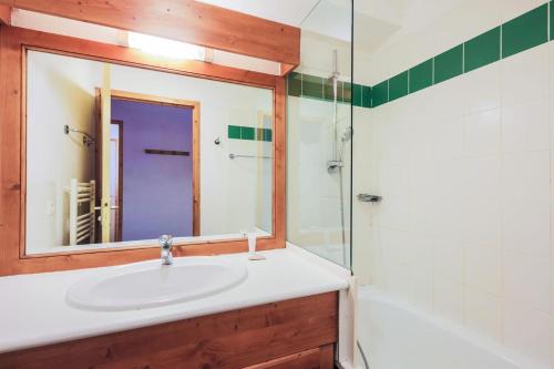 y baño con lavabo y espejo. en Résidence Les Valmonts - maeva Home - Appartement 3 Pièces 6 Personnes - Co 89 en Saint-Martin-de-Belleville