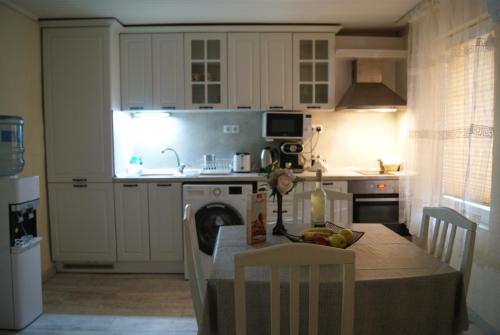 eine Küche mit Tisch und eine Küche mit weißen Schränken in der Unterkunft NIKI Apart in Sofia