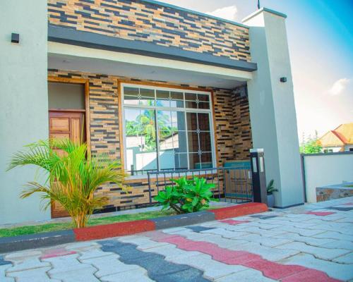 una casa con una finestra e piante davanti di Nellly's Rest House a Dar es Salaam