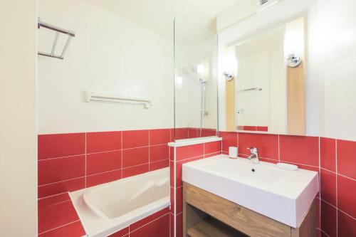 une salle de bain avec un lavabo blanc et un miroir dans l'établissement Résidence Les Gémeaux - maeva Home - Appartement 2 pièces 6 personnes Sélection MAE-3250, à La Plagne Tarentaise
