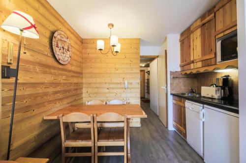 - une cuisine avec des murs en bois et une table en bois dans l'établissement Résidence Les Constellations - maeva Home - Appartement 2 Pièces 5 Personnes - Confort MAE-3350, à La Plagne Tarentaise