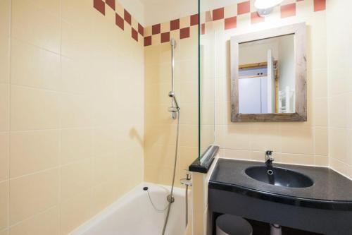 une salle de bain avec un lavabo, une baignoire et un miroir dans l'établissement Résidence Les Constellations - maeva Home - Appartement 2 Pièces 5 Personnes - Confort MAE-3350, à La Plagne Tarentaise