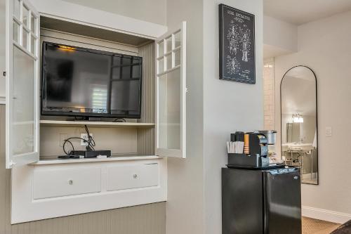 a kitchen with a black refrigerator and a tv at Craftsman Inn in Calistoga