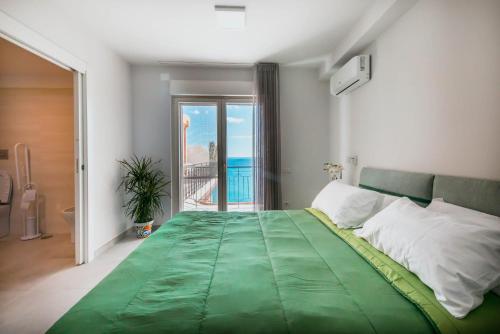 a bedroom with a green bed with a view of the ocean at BLU MARINE in Catanzaro