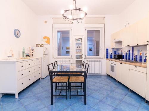uma cozinha com uma mesa de vidro e 2 cadeiras em ARIA DI MARE ROOMS em Cefalù