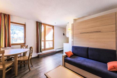 un salon avec un canapé et une table dans l'établissement Résidence Les Ravines - maeva Home - Studio 4 Personnes Sélection MAE-3854, à Les Allues