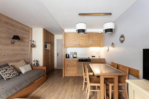 Ce petit appartement comprend un lit, une table et une cuisine. dans l'établissement Résidence Le Christiana - maeva Home - Appartement 2 Pièces 5 Personnes - Sélection MAE-3642, à Saint-Bon-Tarentaise