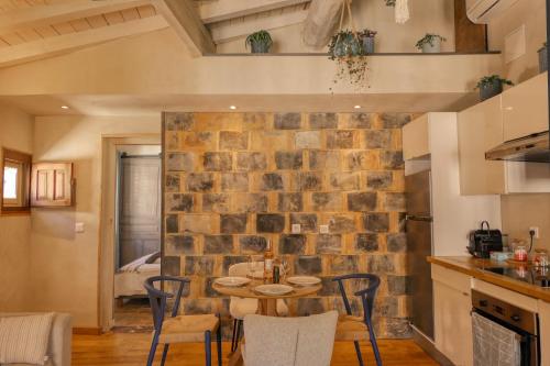 une cuisine et une salle à manger avec un mur en briques dans l'établissement Le Jardin Suspendu, à Avignon