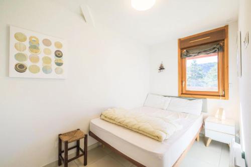 um quarto branco com uma cama e uma janela em Résidence Les Mélèzes - maeva Home - Appartement 2 Pièces 4 Personnes - S 35 em Le Dévoluy