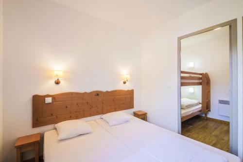 a bedroom with a white bed and a mirror at Résidence Le Hameau des Ecrins - maeva Home - Appartement 2 Pièces 6 Person 50 in Puy-Saint-Vincent