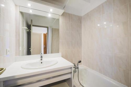 a bathroom with a sink and a tub and a mirror at Résidence Le Hameau des Ecrins - maeva Home - Appartement 2 Pièces 4 Person 62 in Puy-Saint-Vincent