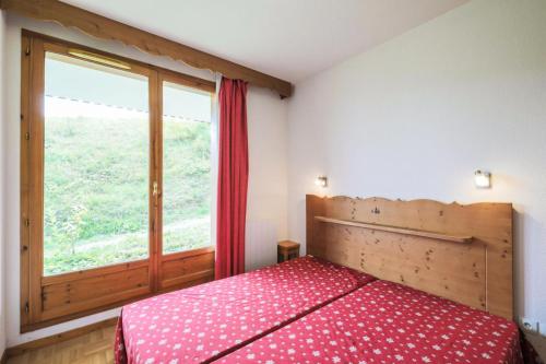 a bedroom with a bed and a large window at Résidence Les Gentianes - maeva Home - Appartement 3 Pièces 6 Personnes - C 38 in Puy-Saint-Vincent