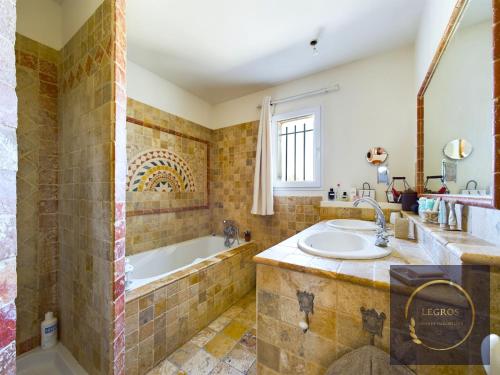 La salle de bains est pourvue d'une baignoire et d'un lavabo. dans l'établissement Maison la Garrigue en Provence, à Maillane