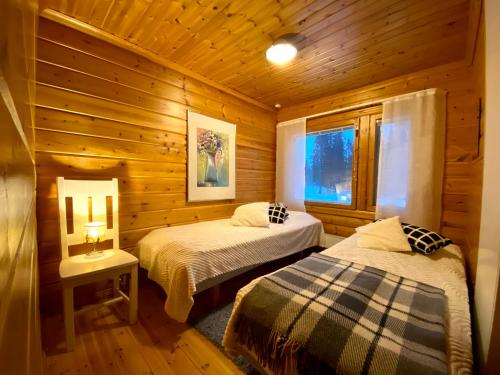 ein Schlafzimmer mit zwei Betten in einer Blockhütte in der Unterkunft Alppiruusu B in Syöte