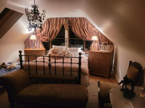 a bedroom with a bed and a chair and a chandelier at Cherrygarth Cottage in White Hall