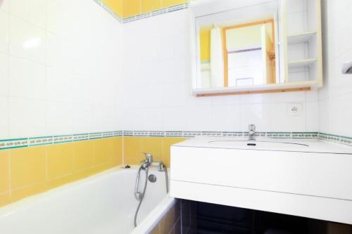une salle de bain avec un lavabo blanc et un miroir dans l'établissement Quartier Crève Cœur - maeva Home - 2 Pièces 5 Personnes Confort MAE-5851, à Valmorel