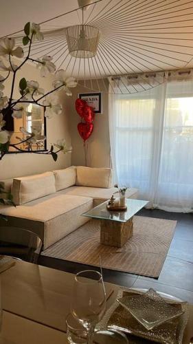 un salon avec un canapé et une table dans l'établissement Logement accès JO avec Jardin et Jacuzzi, à Bussy-Saint-Georges
