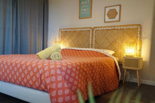 um quarto com uma cama com uma colcha laranja em Studio indépendant a 20min des plages em Castelnau-de-Guers