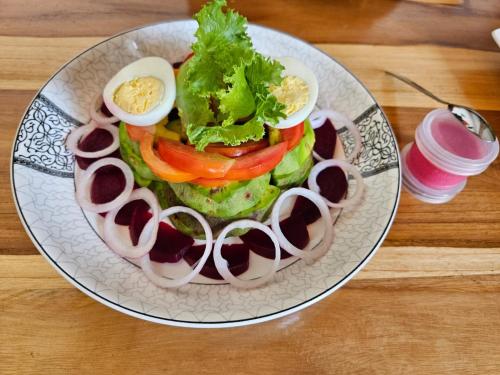 um prato com uma sanduíche com ovos e legumes em Hotel Eyram Kpalime em Palimé