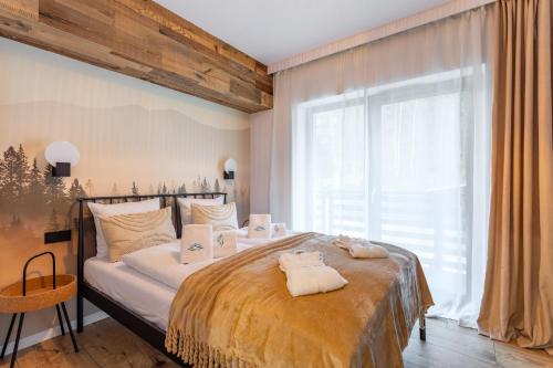 - une chambre avec un grand lit et des serviettes dans l'établissement Obrońców Pokoju 14, à Szklarska Poręba
