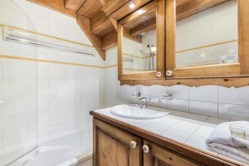 une salle de bain avec un lavabo et une baignoire dans l'établissement Résidence Les Fermes du Soleil - maeva Home - Appartement duplex 4 Pièces 8 Personnes - Prestige MAE-6447, aux Carroz d'Arâches