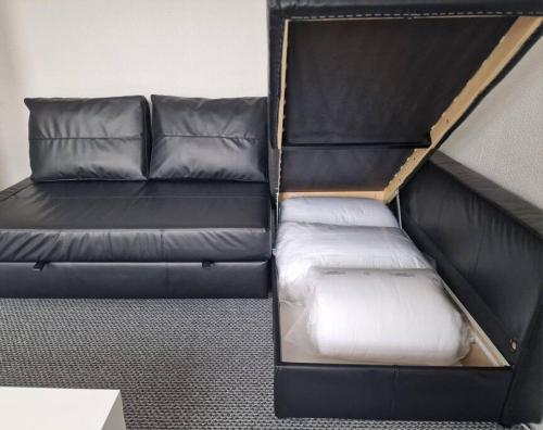 a black leather couch in a living room at Comfy Apartment - Nottingham Centre - Free Parking in Nottingham
