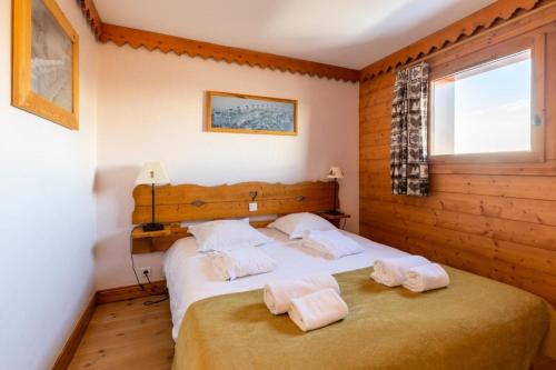 une chambre avec un lit avec deux serviettes dessus dans l'établissement Résidence Le Roselend - maeva Home - Appartement 2 Pièces 6 Personnes - Sélection MAE-6508, à Bourg-Saint-Maurice