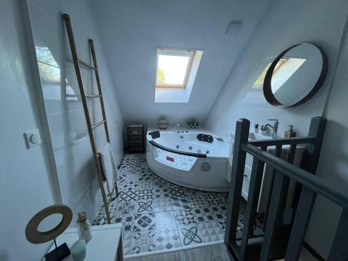 y baño con bañera blanca y espejo. en LE NID - Charmante petite maison avec balnéo, en Gambais