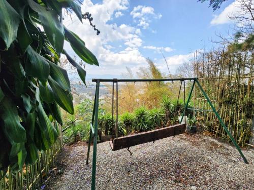 a swing set in a garden with a view at CABAÑAS EN ZONA 16 in Guatemala