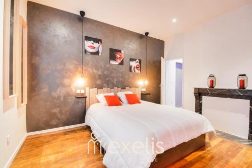a bedroom with a large bed and a fireplace at Charles sous le Charme in Nancy