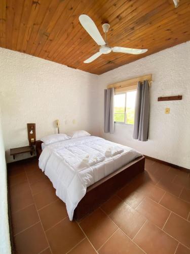 a bedroom with a large bed with a ceiling fan at Posada TyM in Trinidad