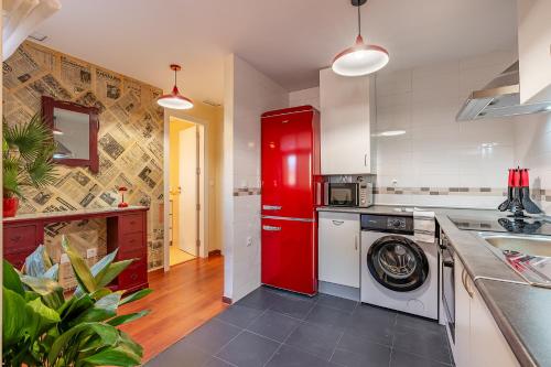 a kitchen with a red refrigerator and a washing machine at Mirador del Ocaso in La Zubia