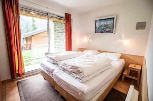 Ce lit se trouve dans un dortoir doté d'une grande fenêtre. dans l'établissement Les Chalets Petit Bonheur - Chalets pour 6 Personnes 494, à Villarodin-Bourget