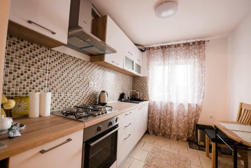 a kitchen with a stove top oven next to a window at Apartment Jazz in Požega