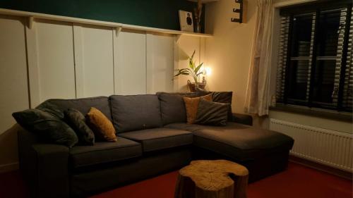 uma sala de estar com um sofá e uma mesa em Gastenhuisje em Zelhem