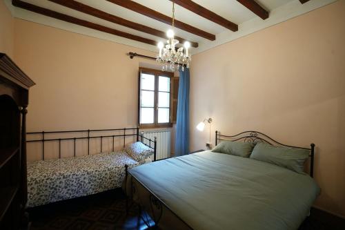 una camera con letto, finestra e lampadario a braccio di LE VOLTE centro storico di Poppi a Poppi