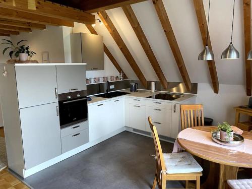 a kitchen with white cabinets and a wooden table at Ferienwohnung Leonardo in Badem