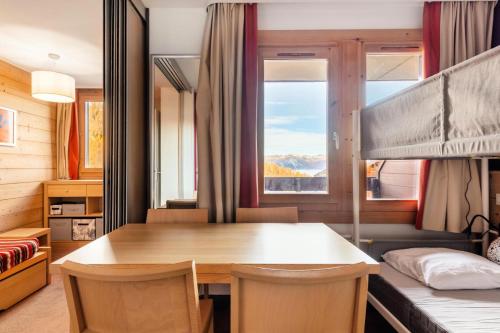 Cette chambre comprend une table, un lit et une fenêtre. dans l'établissement Résidence Plagne Lauze - maeva Home - Studio 4 Personnes - Confort MAE-5774, à Mâcot La Plagne