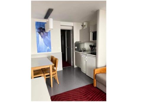 une petite cuisine avec une table et une salle à manger dans l'établissement Résidence Antarès - maeva Home - Studio 4 personnes - Confort MAE-8504, à Avoriaz