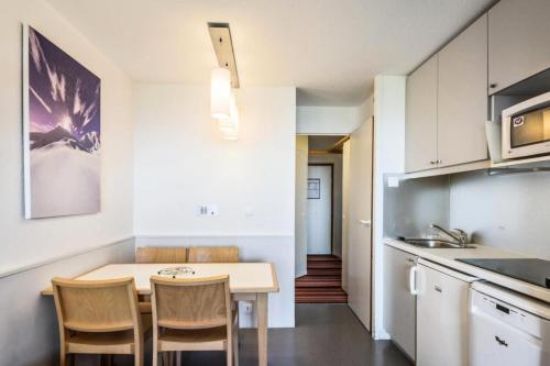 une cuisine avec une table et des chaises dans une pièce dans l'établissement Résidence Quartier Falaise - maeva Home - Studio 4 personnes - Sélection MAE-0474, à Avoriaz