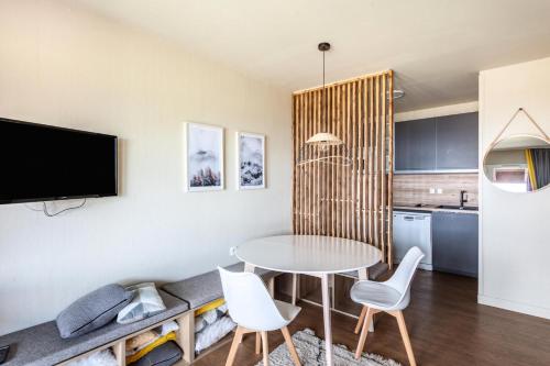 une cuisine et une salle à manger avec une table et des chaises dans l'établissement Résidence Le Thabor - maeva Home - Appartement 3 Pièces 6 Personnes - Prestige MAE-9204, à Le Désert