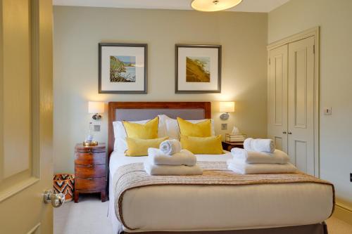ein Schlafzimmer mit einem Bett mit Handtüchern darauf in der Unterkunft Pope Lodge: Stunning Stone Coach House Conversion in Alnmouth