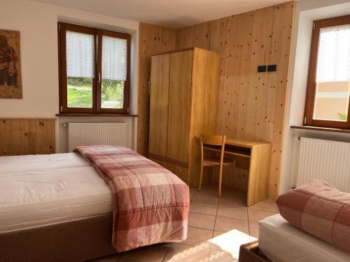 a bedroom with a bed and a desk at Appartamento Andalo per famiglie, lontano dal caos in Andalo