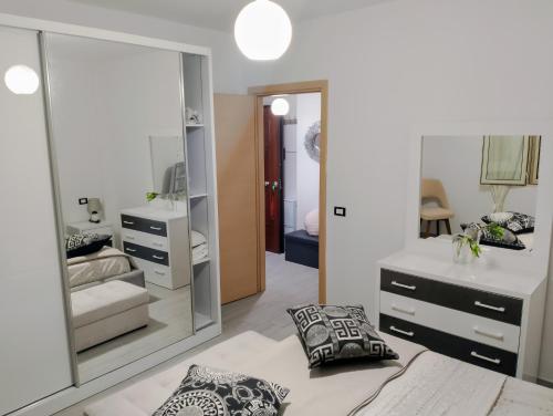 een slaapkamer met een spiegel, een bed en een wastafel bij ASHLEY APARTMENTS in Durrës