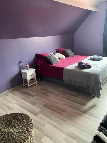 een slaapkamer met een bed met roze lakens en een houten vloer bij maison des caucases in Baron