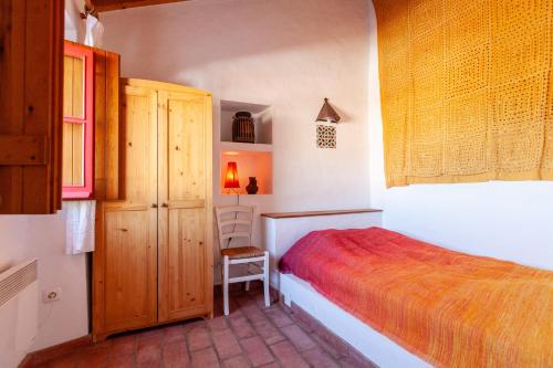 a bedroom with a bed and a chair in it at Casa Bene Holiday Home in Aljezur