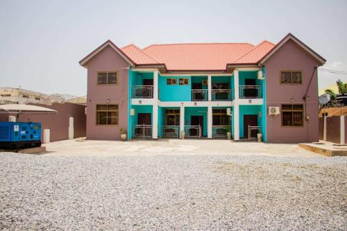 une grande maison bleue et rose dans l'établissement Accra cosy homes near beaches and mall, à Accra